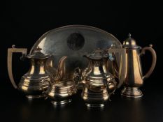 A collection of silver plate to include three tea pots, a creamer, sugar pot and a tray with marks