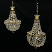 Two French Empire style chandeliers each having a flowerhead finial on a brass collar above a