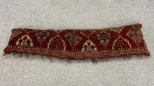 A 20th century draft excluder or large cushion handmade from a piece of carpet with a patterned
