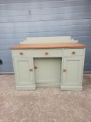 A 19th century painted pine farmhouse kneehole style dresser having a thick plank top with a