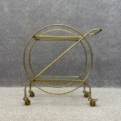 A contemporary Art Deco style drinks trolley having a rectangular glass top and undertier