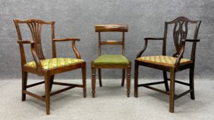 A Georgian oak Hepplewhite style elbow chair having a shaped wishbone top rail above a pierced