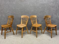 A set of four 20th century beech dining chairs each having a curved top rail with a turned spindle
