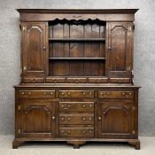 A 20th century Georgian style oak dresser having a moulded cornice with a shaped apron above two