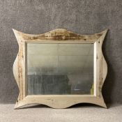 A large contemporary painted and distressed wall mirror of stylised quatrefoil form with a