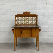 An early 20th century washstand having a shaped and carved gallery back inset with ten tiles on a