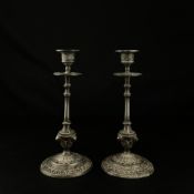 A pair of 19th century pewter candlesticks each having a flared finial with a scrolling foliate