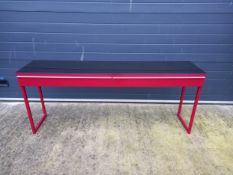 A contemporary console table with a plate top over two frieze drawers on metal supports. L.180cm H.