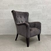 A contemporary wingback armchair in buttoned piped velour upholstery. H.100cm