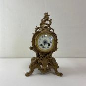 A 19th century French gilt metal mantle clock having a a circular enamelled dial bearing stylised