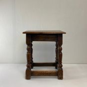 An oak joint stool in the 17th century Jacobean style having a rectangular thumb moulded top