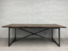 A large contemporary distressed teak refectory style dining table having a heavy plank top raised on