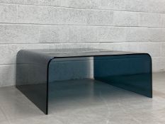 A contemporary bent smoked glass coffee table. H.40 W.100 D.100cm