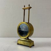 A brass gravity mantle clock having a moulded cornice above the black dial with hand painted