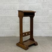 A 20th century oak prayer stand having a sloped top over a small recess raised on shaped trestle