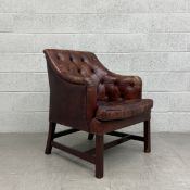 A Georgian style desk or library armchair having a square deep buttoned back with shaped arms over a