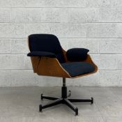 A mid-century Eames style bent ply and black fabric upholstered swivel office chair raised on a five