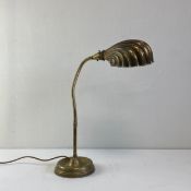 An early 20th century brass Art Deco clam shell table lamp with an adjustable stem raised on a