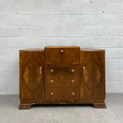 A mid 20th century Art Deco style walnut drinks cabinet having a stepped top over a central