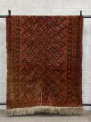 A 19th century Persian style Baluch carpet having a geometric diamond gul lozenge pattern field over