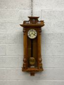 A 19th century walnut Vienna wall hanging clock having a carved and turned crest with a central