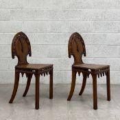 A pair of 19th century oak Gothic Revival hall chairs each having an arched and carved openwork back