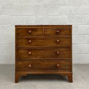 A Georgian mahogany chest of drawers having a rectangular crossbanded top over an arrangement of two