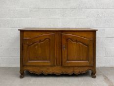 A 19th century French walnut sideboard or dresser having a rectangular plank top over an arched