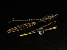 Three 9ct gold bar brooches to include one of elliptical form with a central flowerhead inset with