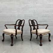 A pair of mahogany Chippendale style open armchairs each having a shaped top rail with curved arms