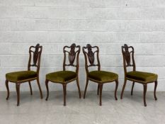 A set of four late 19th century mahogany dining chairs each having a shaped top rail and carved