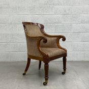 A William IV mahogany library tub armchair having a curved top and scrolling arms with a