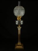 A Victorian brass Corinthian column oil lamp having a frosted greek key glass globe and plain