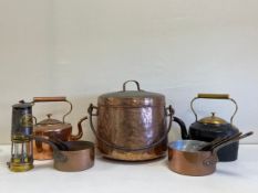 A mixed collection to include eleven copper pots and a kettle, a cast iron brass lidded kettle and a