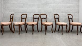 A set of six 19th century mahogany dining chairs with shaped and carved backs above stuffover