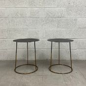 A pair of contemporary side or lamp tables each having a circular sheet metal top raised on a
