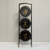A 20th century black lacquered Chinoiserie cakestand having a shaped top rail over three folding