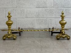 A pair of 19th century French Empire style brass firedogs or andirons each of turned baluster form
