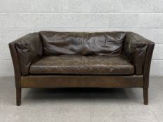 A contemporary John Lewis Halo Groucho distressed leather two seater sofa having a square back and