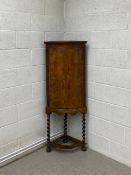 An early Georgian walnut and crossbanded bowfronted corner cabinet on stand with barleytwist