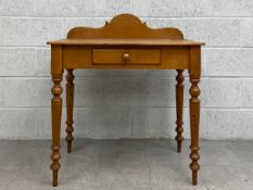 A C.1900 pine side table having a shaped gallery back over a rectangular thumb moulded plank top