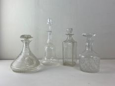 A collection of four blown and cut glass decanters to include one with a shipping themed engraved