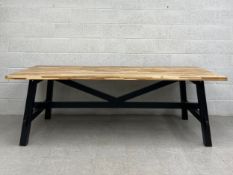 A contemporary Ikea Skogsta refectory style dining table having a parquetry Acacia top raised on a