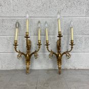 A pair of 19th century French Empire style gilt metal wall sconces each having three scrolling
