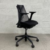 A contemporary Herman Miller Sayl office chair having a tapering meshwork suspension back with a