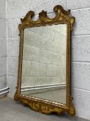 An early Georgian fret cut mirror having a rectangular plate in a carved and shaped giltwood