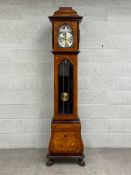 A contemporary walnut longcase clock having a stepped marquetry inlaid caddy top with a moulded