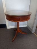 A Georgian style teak drum table having a circular top fitted with a piece of protective glass