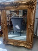 A large 19th century style mirror in a heavy ornate gilt frame. 130x99cm