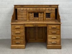 A 19th century style oak roll top desk with serpentine tambour shutter revealing a fitted interior